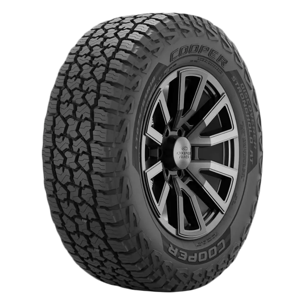 A Cooper tire with an aggressive tread pattern and a black alloy rim.