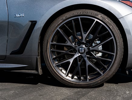 Close-up of a car's alloy wheel with a Sumitomo tire and a 3.0t badge on the vehicle's body, shown in a metallic gray finish.