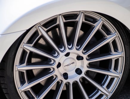Close-up view of a stylish alloy wheel with a multi-spoke design and a center cap labeled "Niche," mounted on a car.