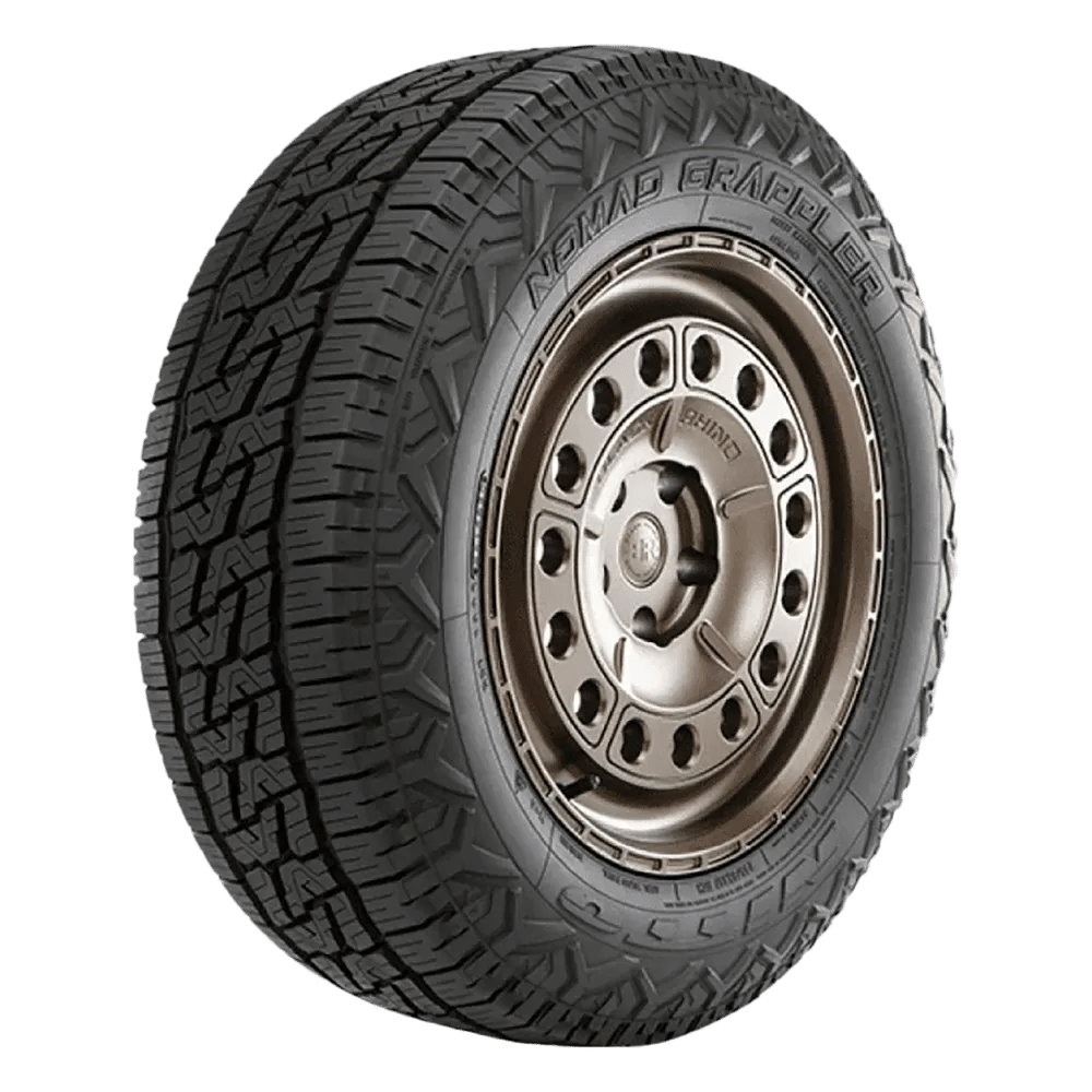 A Nomad Grappler tire featuring rugged tread patterns and a metallic wheel rim with multiple holes around the perimeter.