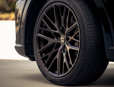 Close-up of a car tire with a black, intricately designed alloy wheel featuring the DUBEN logo.