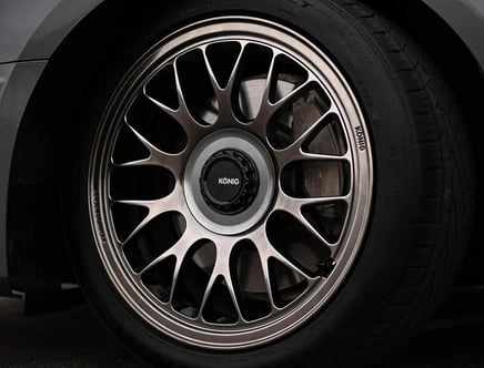 A close-up of a stylish alloy wheel with a multi-spoke design and the brand name "König" on the center cap, mounted on a car tire.