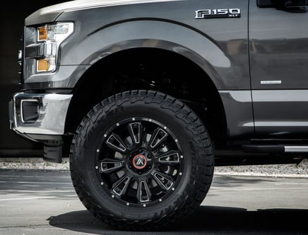 Close-up of the front left wheel and fender of a gray Ford F-150 XLT truck with a visible tire and EcoBoost badge.