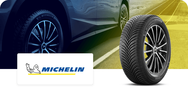 Michelin tire displayed in front of a car on a road, with the Michelin logo visible in the image.