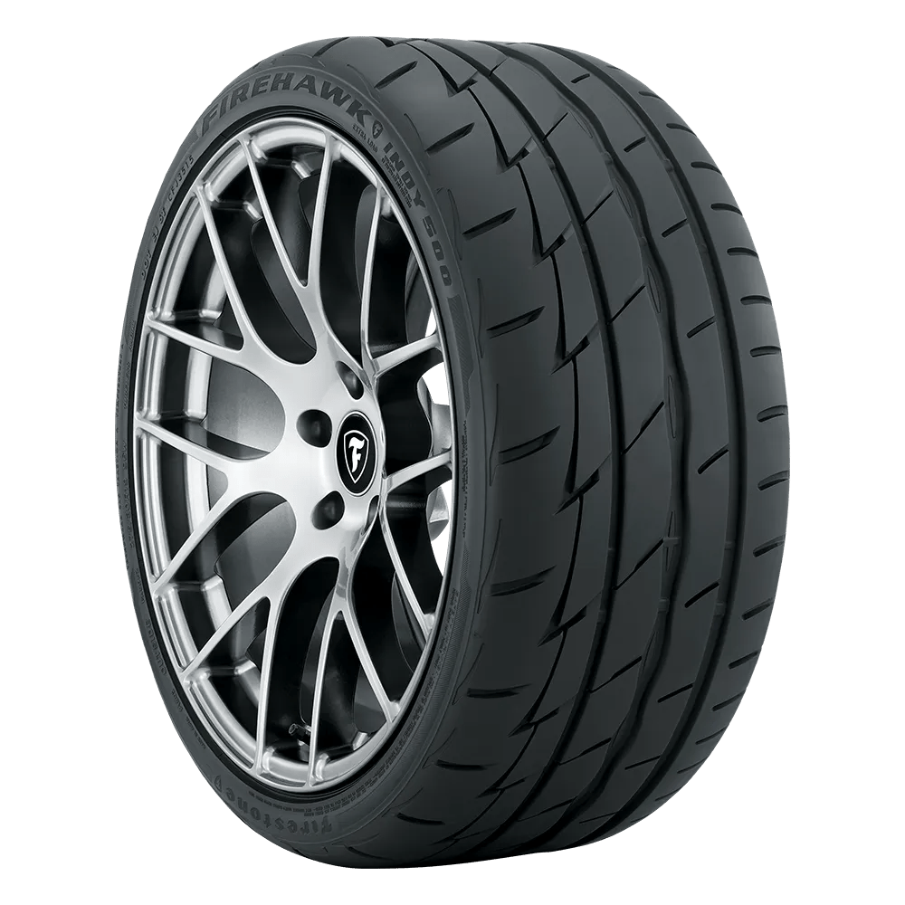 A Firestone Firehawk Indy 500 summer tire mounted on a chrome wheel with the Firestone logo.